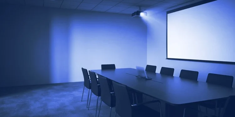 An empty meeting room with a blank lit projector screen, for what AI presentation evaluation jobs involve