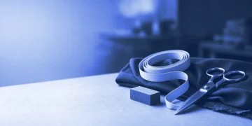 A tailor's tape, chalk and scissors on a cutting table, for an AI trainer resume template built to fit