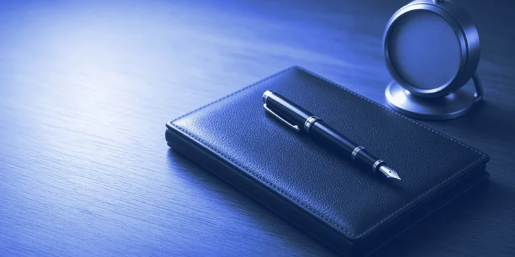 A closed leather portfolio with a fountain pen and a small desk clock, for finance AI trainer jobs