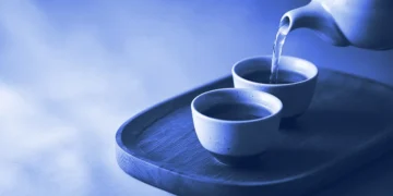 A teapot pouring into one of two teacups on a tray, for how Mercor referral program earnings sharing works
